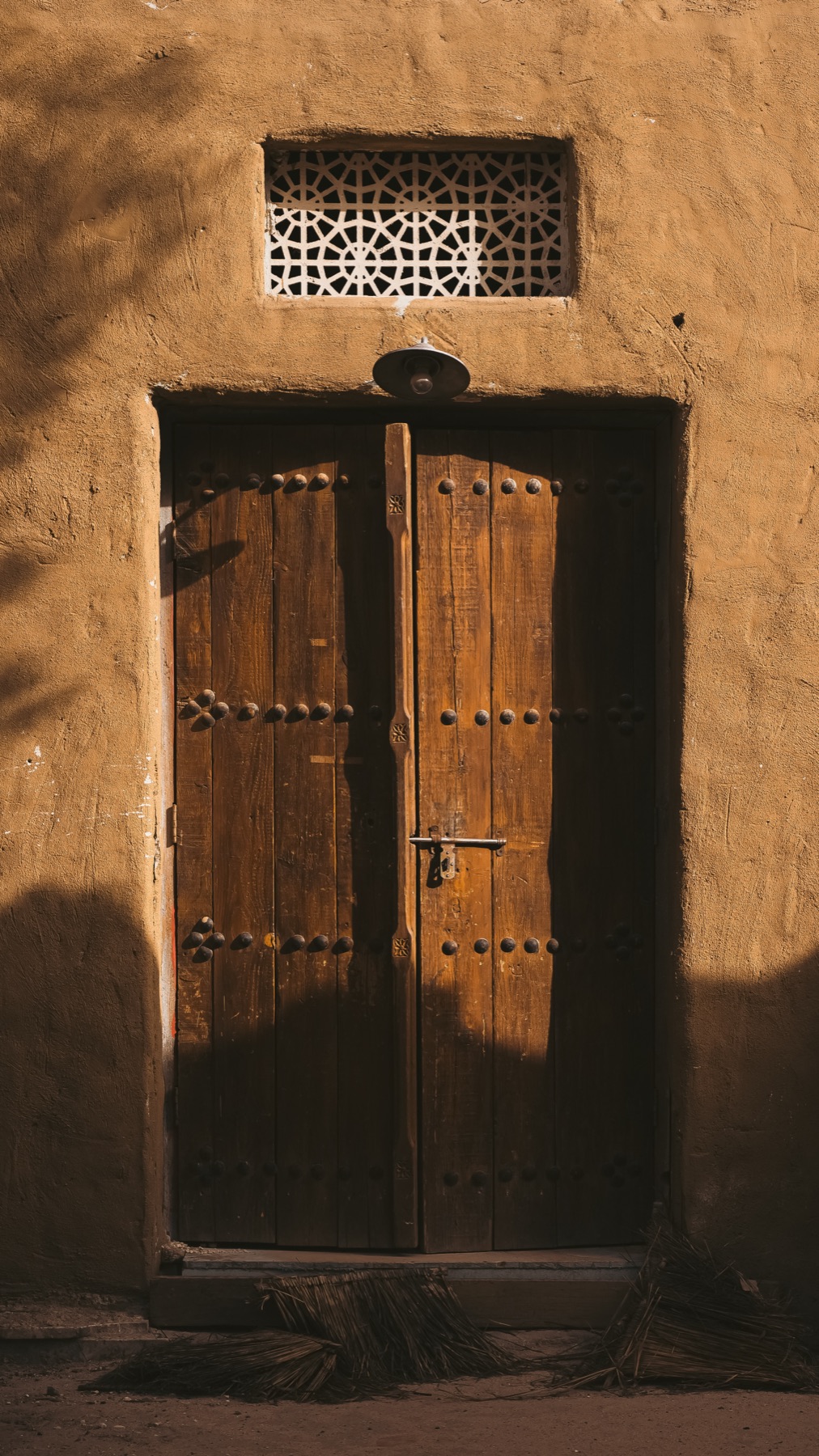 A traditional wooden double door set in an earthen wall
