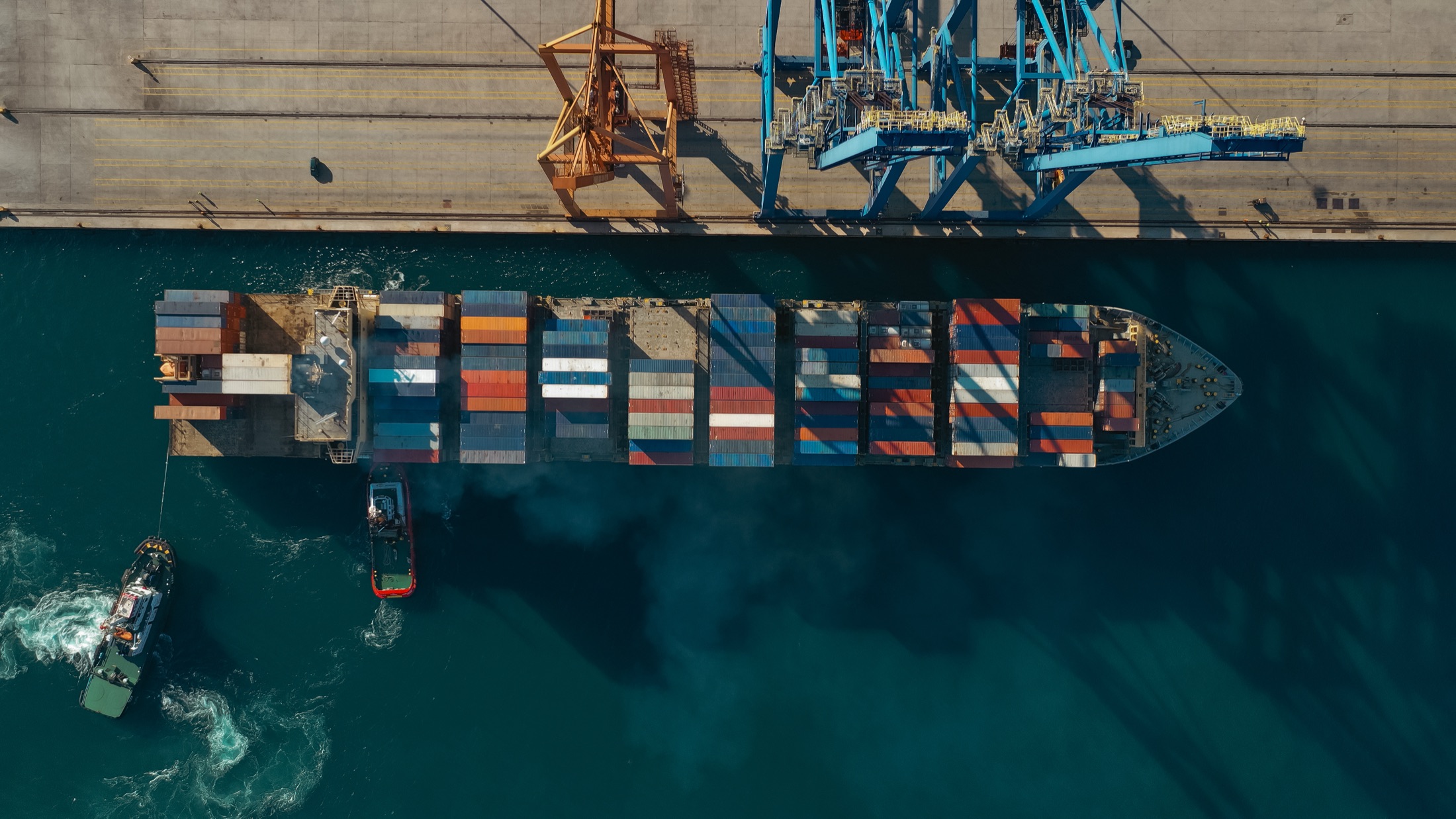An aerial view of container cranes at a commercial port